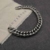 Silver bracelet on textured fabric background.