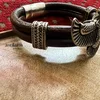 Leather bracelet with silver accents on table.