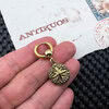 Gold coin keyring on textured paper backdrop.