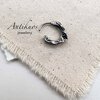 Silver earring on textured cloth background