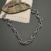 Intricate silver chain on stone and fabric.