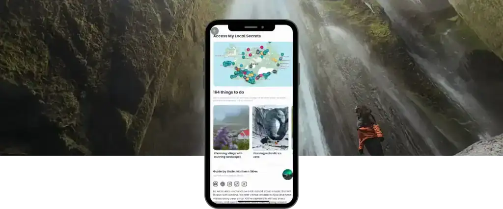 Smartphone mock-up centred in front of a towering waterfall, with a person in an orange jacket standing to the right and looking up at the falling water. The phone screen shows a Rexby travel guide interface with a map covered in coloured pins and the text “164 things to do,” alongside activity images. At the bottom, it reads “Guide by Under Northern Skies,” highlighting a curated local travel experience.