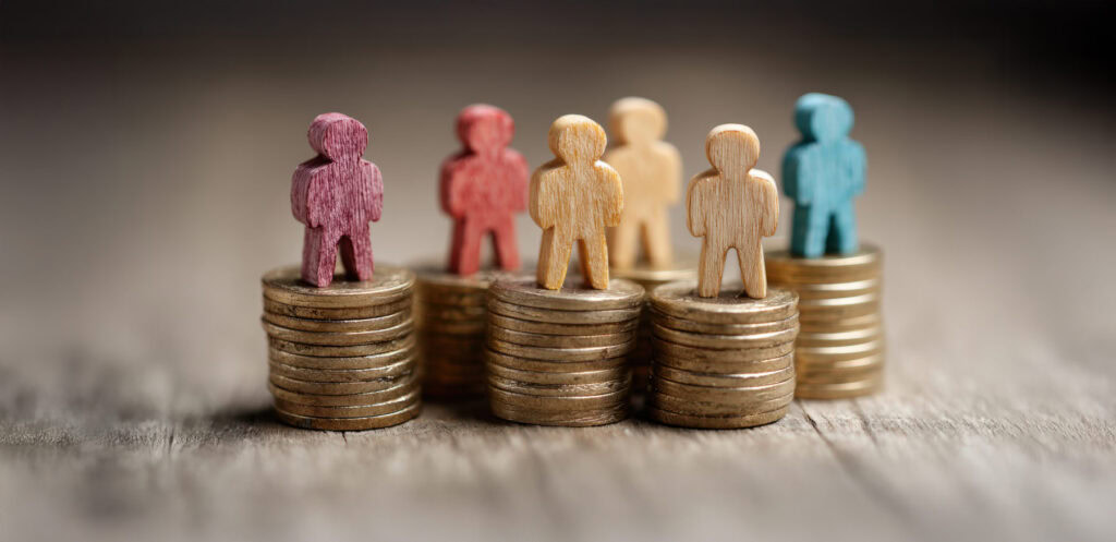 Jobsicherheit vs. Gehalt - Spielfiguren auf Geldstapeln