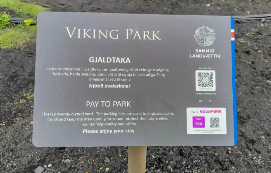 Viking Park pay to park sign with QR code and parking fee details in Icelandic and English.