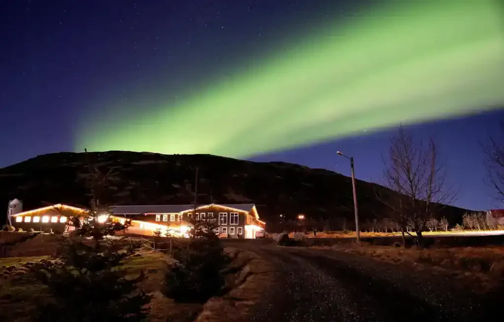 The Northern Lights shining above a hotel in Iceland