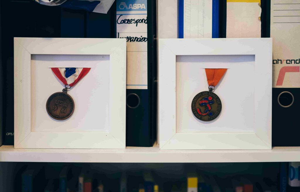 A photo of two medals in frames on a mantlepiece 