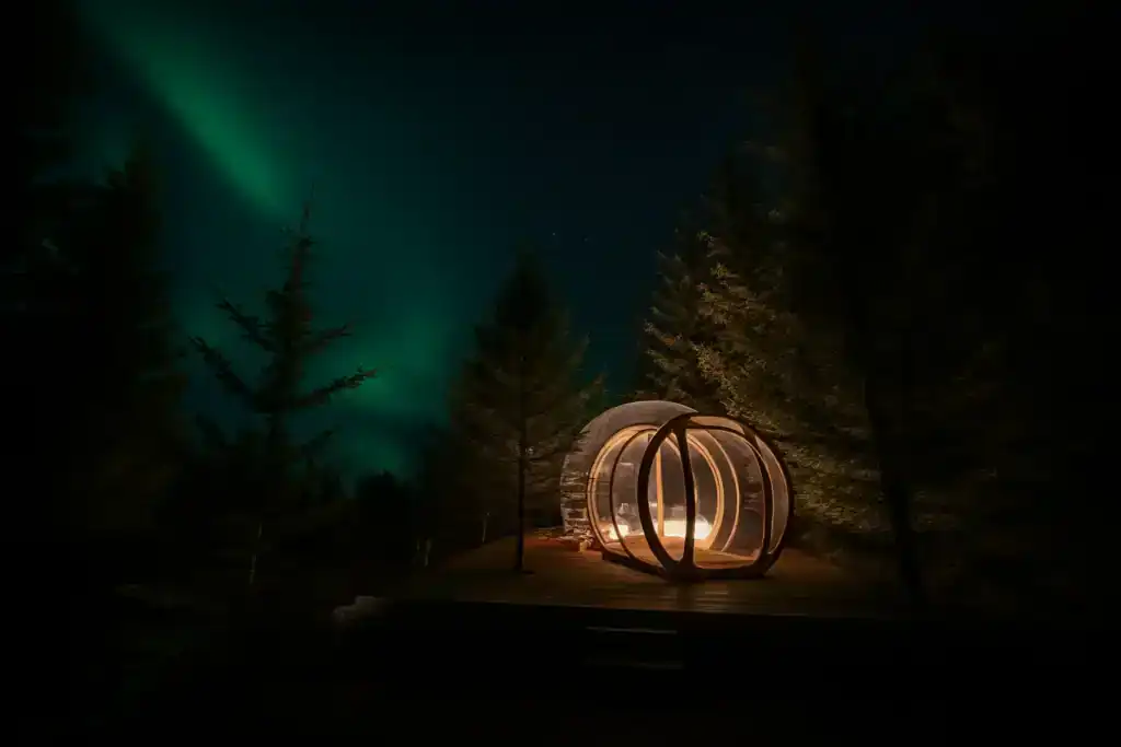 Futuristic circular structure illuminated at night under the Northern Lights in a forest setting.