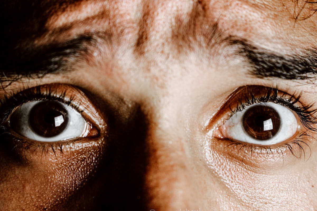 Nahaufnahme weit geöffneter Augen mit ängstlichem Blick.
