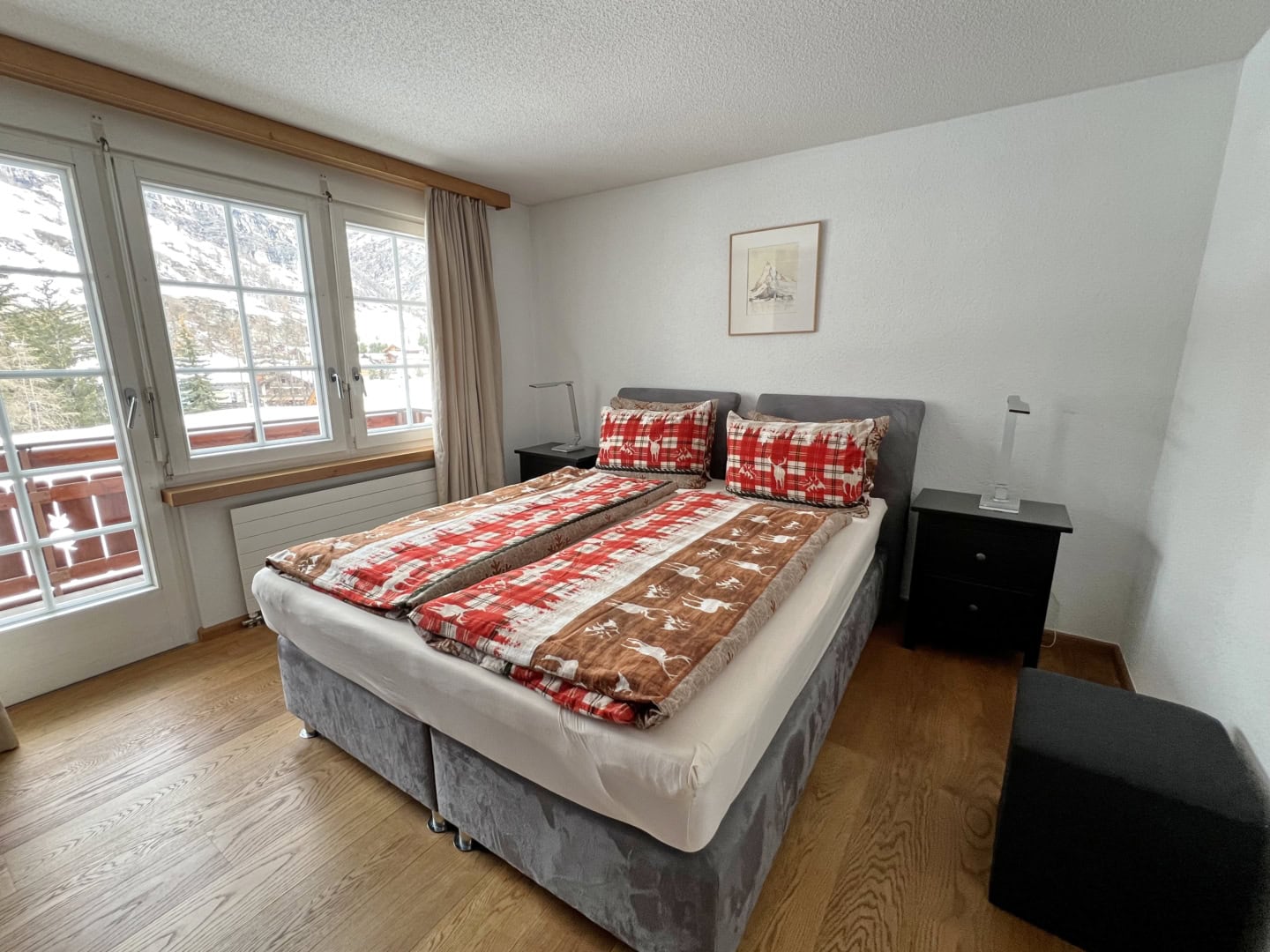 Schlafzimmer mit Boxsprsingbett und Holzboden