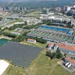 A futuristic cityscape with solar panels, wind turbines, and smart infrastructure showcasing sustainable innovation