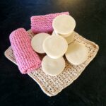 Face Glow tallow soap, Calm - NZ, round pale bars stacked on a cream crochet cloth with pink knitted face cloths, handmade by Fatglow