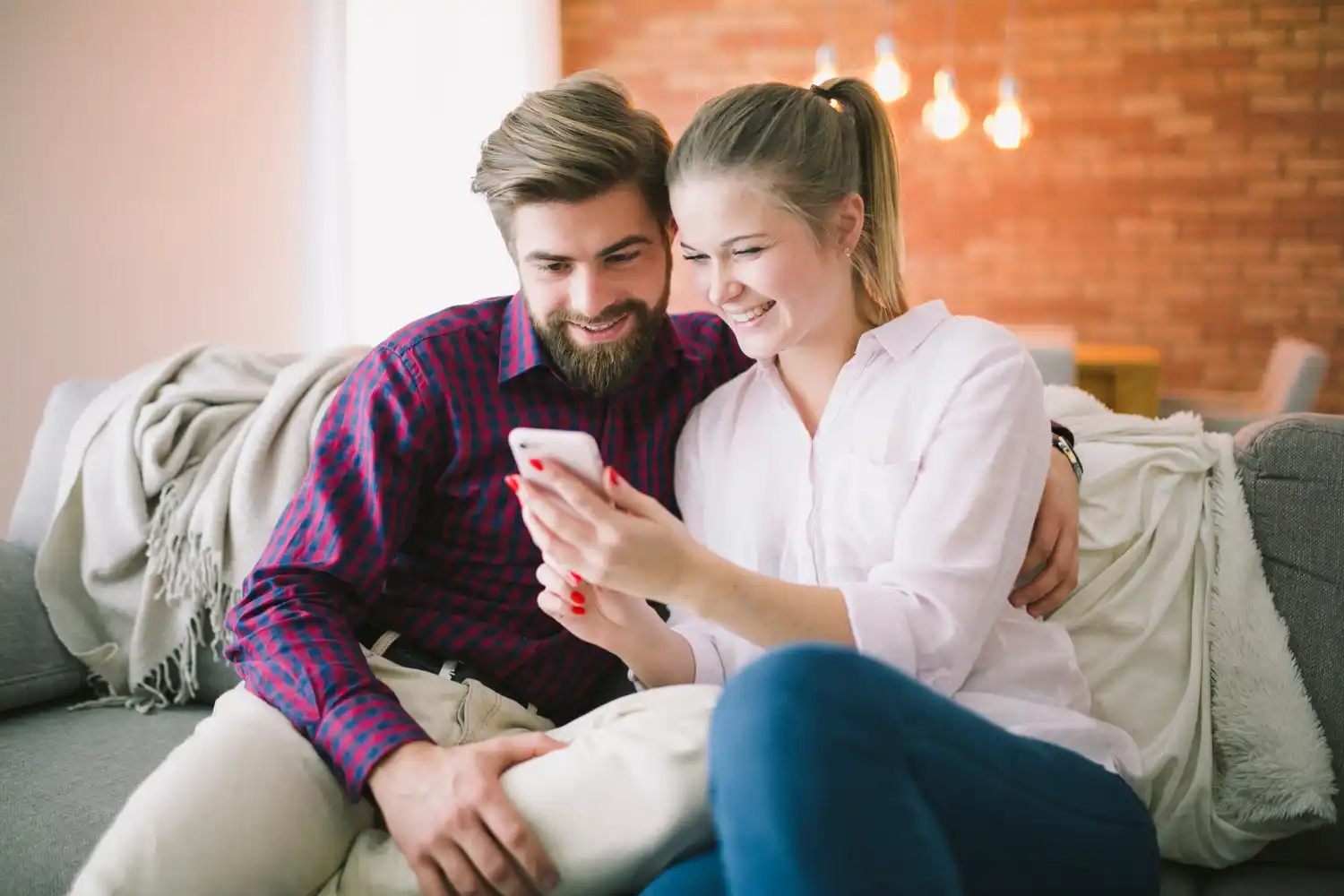 Man and woman smiling and using smartphone Man and woman smiling and using smartphone