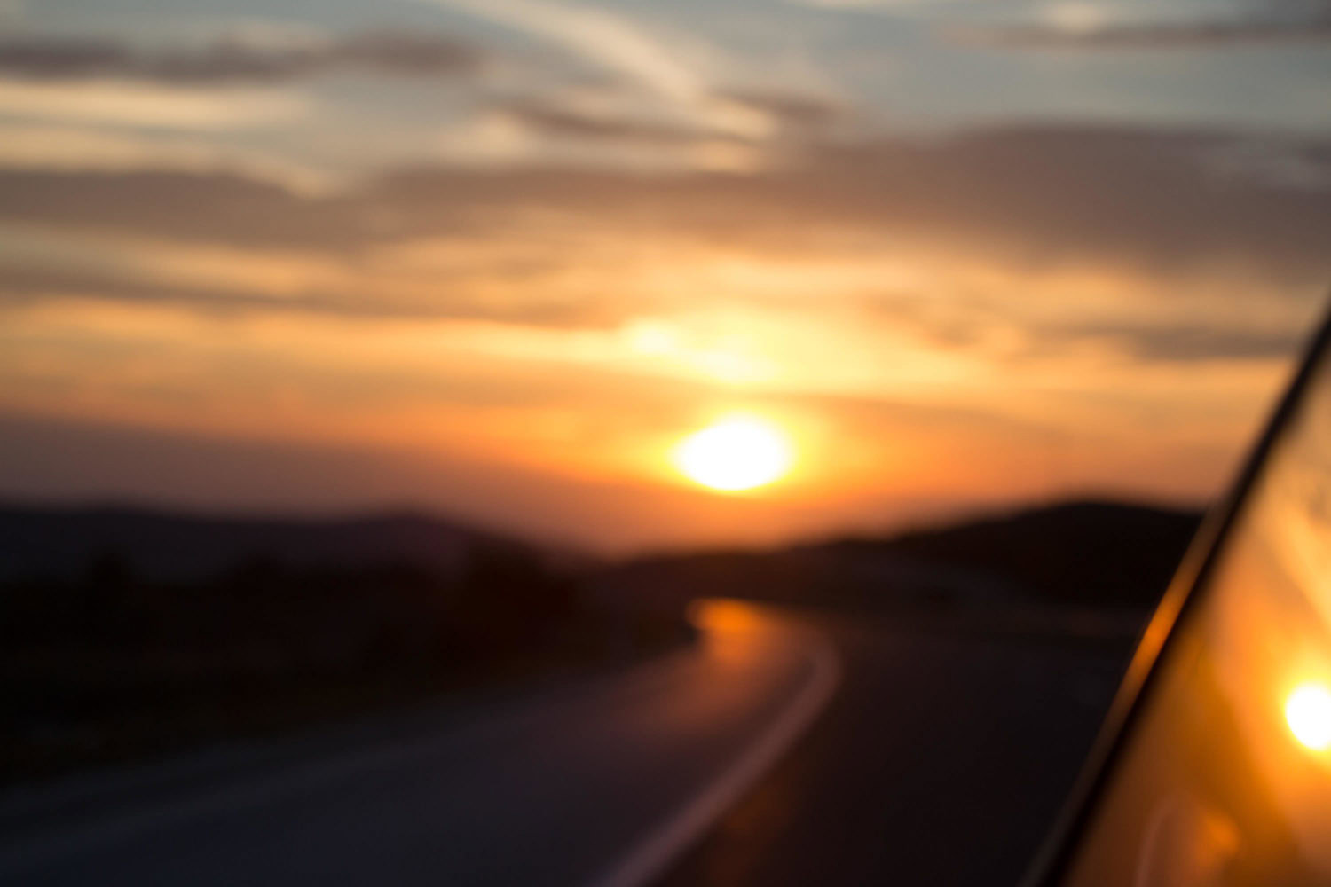 Untergehende Sonne über unscharfer Straße