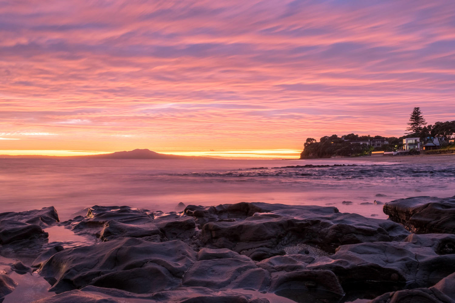 Sonnenaufngang am Milford Beach in Auckland
