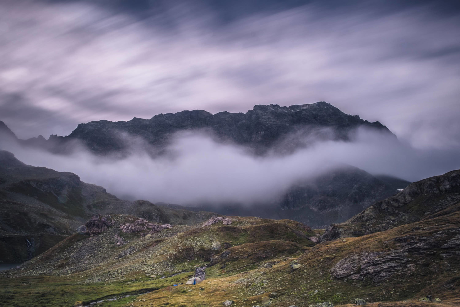 Langzeitbelichtung von Wolken vor einer Bergkulisse in Bivio in