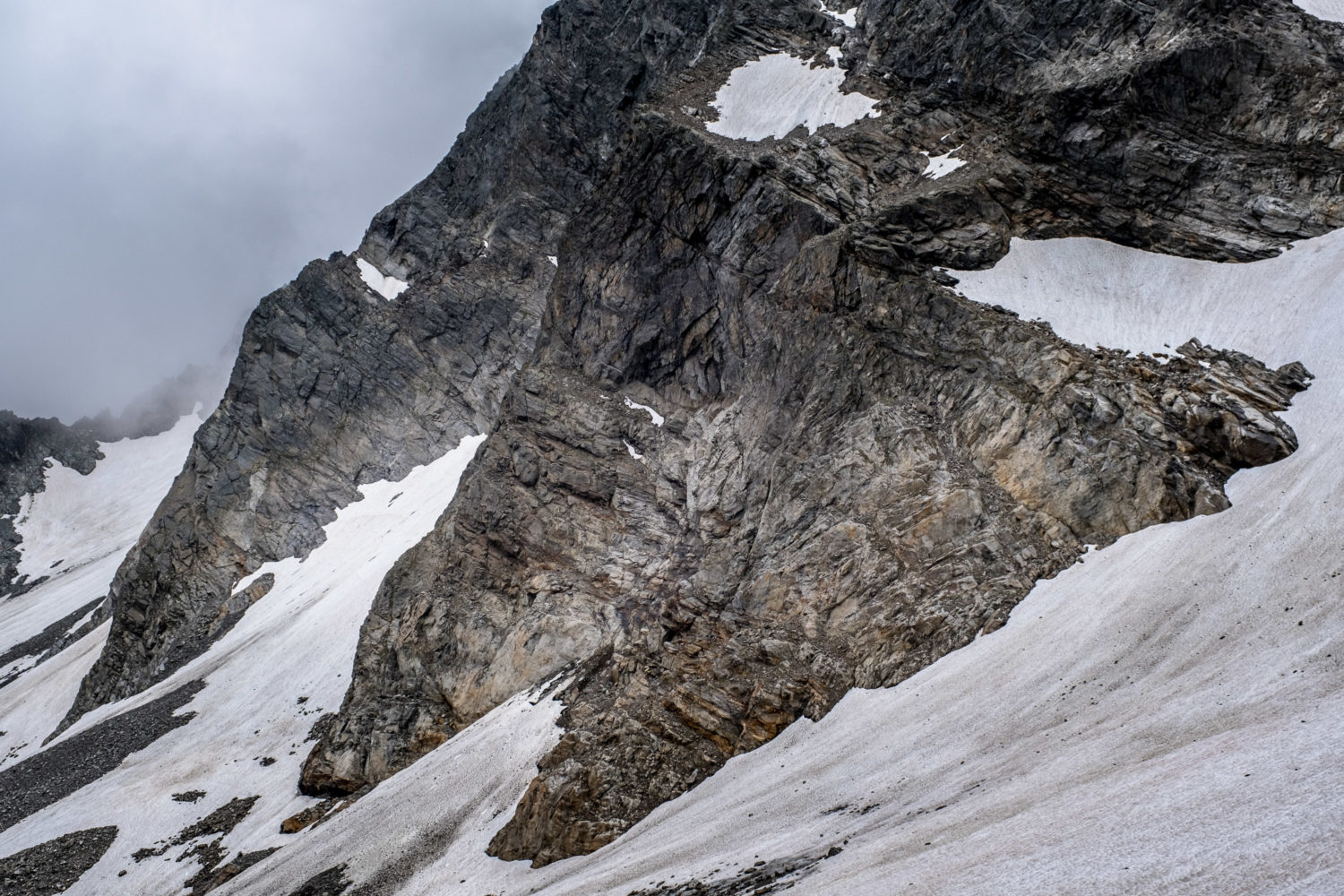 Altschneefeld und schroffe Felsen im Verwall