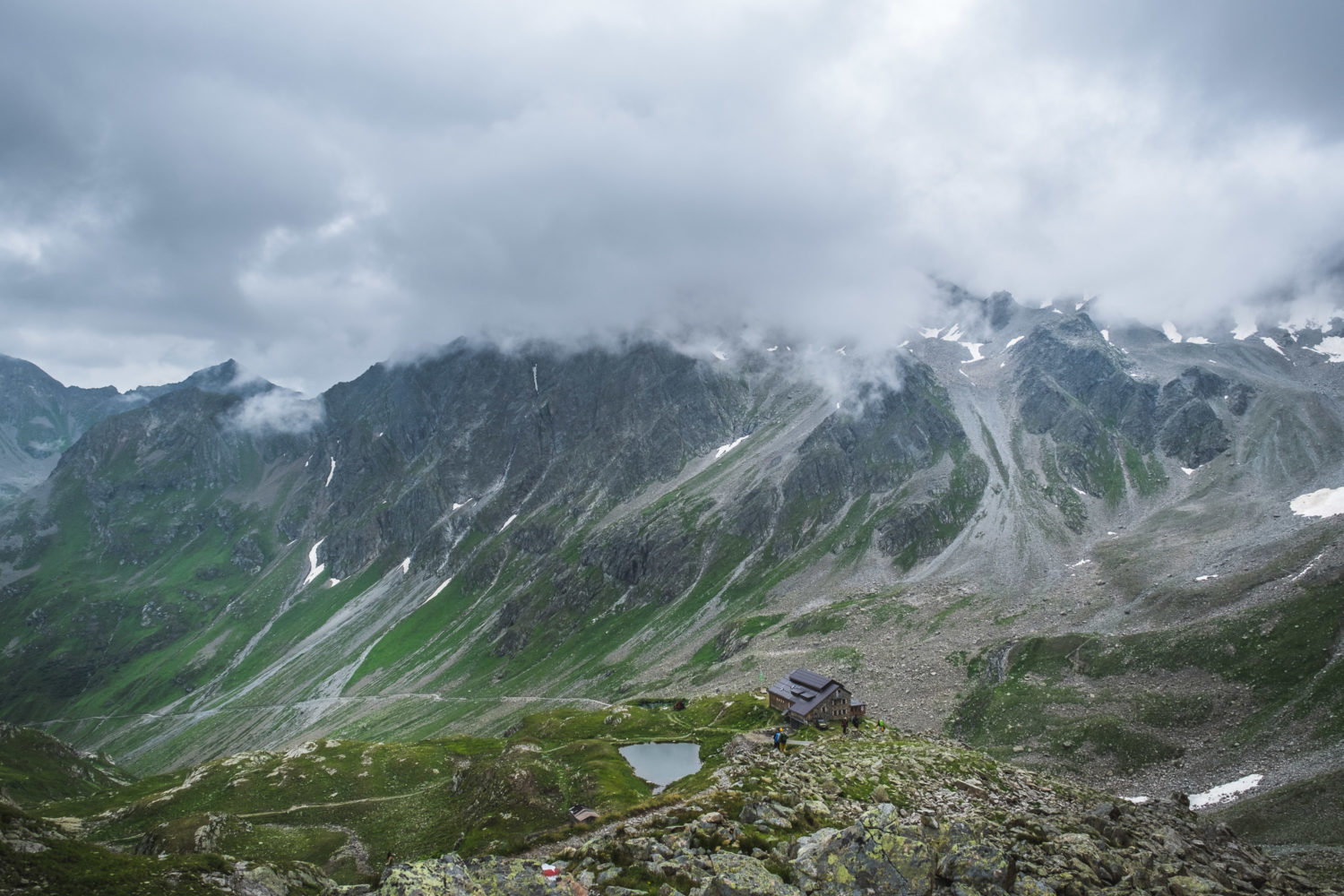 Panorama der Darmstädter Hütte mit Wanderern und umgebenden Bergen