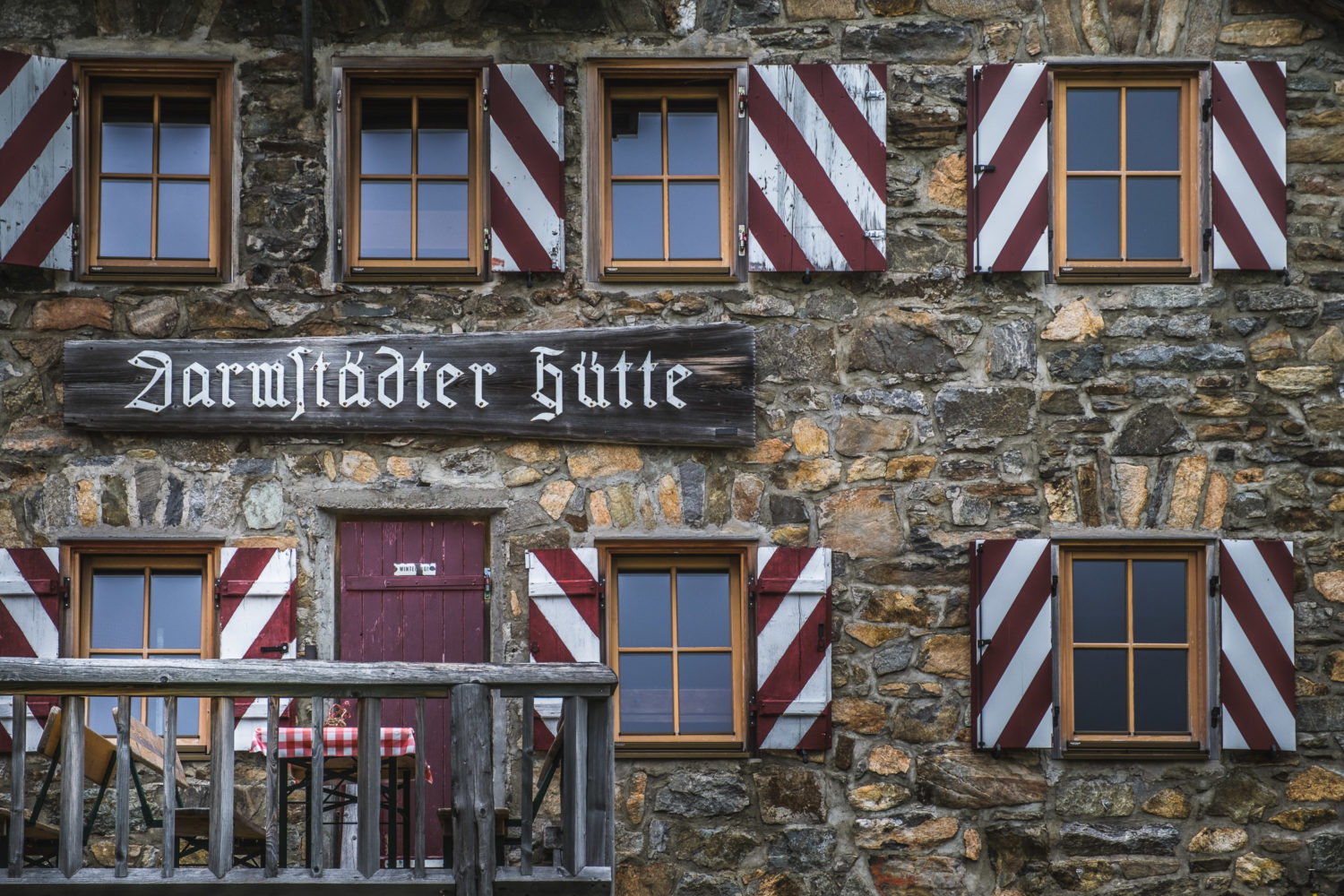 Eingang der Darmstädter Hütte mit Fenstern und rot weißen Fensterläden
