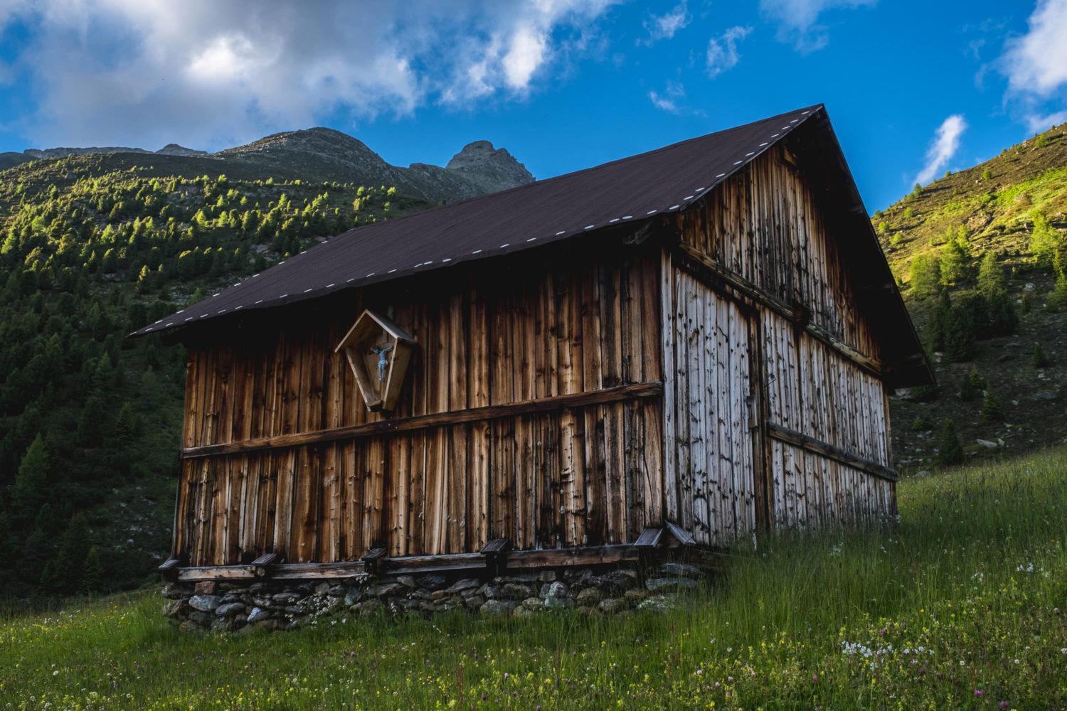 Scheune auf einer Wiese in den Bergen