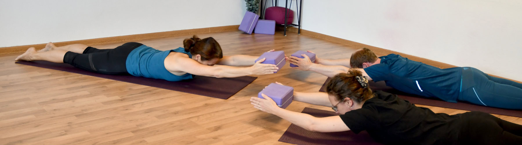 Medical Yoga Lehrerin Kerstin Frank gemeinsam mit einer Kleingruppe beim Yoga.