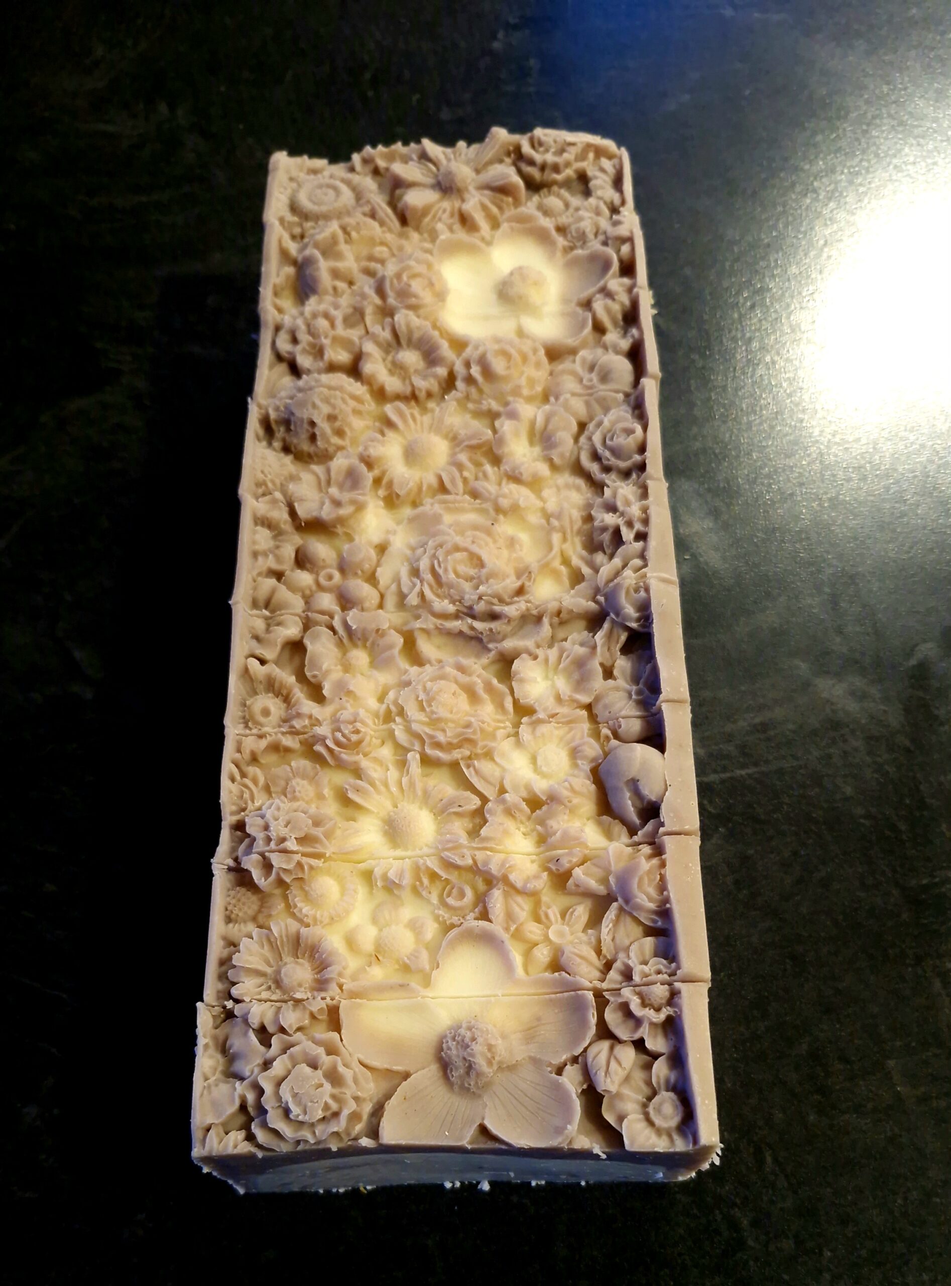 Pale lavender clay tallow soap loaf with an intricate floral embossed top, handmade by Fatglow
