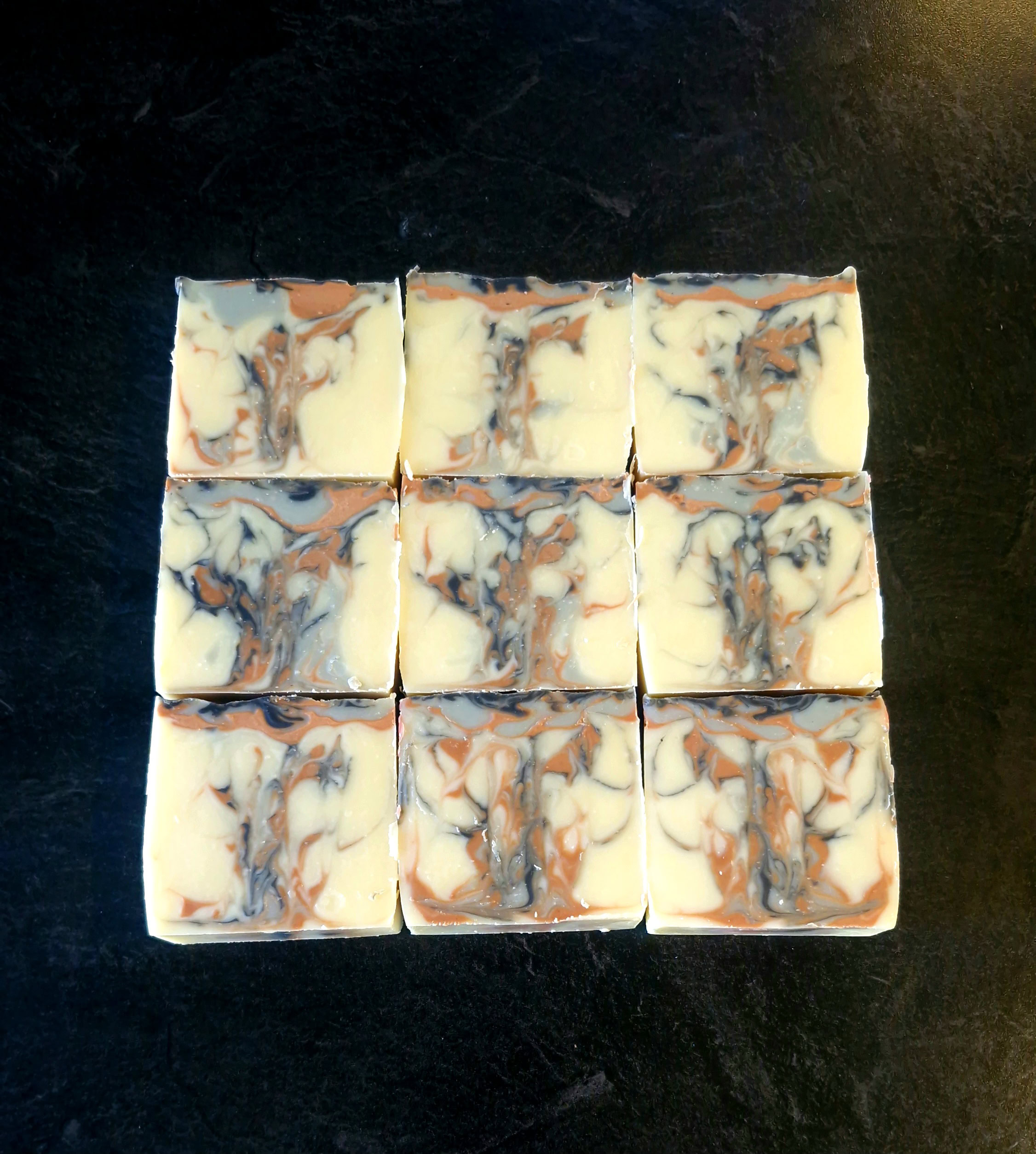 Sliced tallow soap bars NZ with rose and red clay, activated charcoal and blue indigo marbling in cream, terracotta and charcoal, handmade by Fatglow