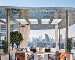 جلسة خارجية فاخرة في كافيه بدبي تطل مباشرة على برج خليفة وقت الغروب.