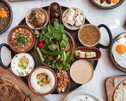 صينية فطور شرقية متنوعة تضم الفول والفلابل والأجبان في مطعم تراثي بدبي.