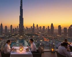 المصورة التي تجلس في جلسات خارجية: "مطعم راقي على شاطئ البحر في دبي مع جلسات مريحة وإضاءة ليلية جذابة.