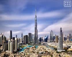 أضواء وسط مدينة دبي ليلاً مع انعكاس برج خليفة على البحيرة