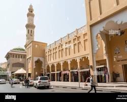 أمام التجارية ليلية معجبين في شارع نايف دبي مع إضاءة المحلات وحركة المتسوقين.