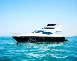 يخت سياحة فاخرة يبحر في مياه البحر الأزرق بالقرب من عجلة عين دبي في جزيرة بلوواترز