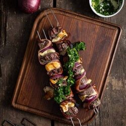 Grillspieße mit saftigem Rindfleisch, knusprigem Bacon und geschmolzenem Camembert auf einem Grillrost