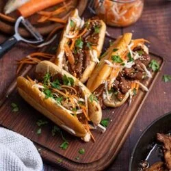 Fertiges Banh Mi Sandwich mit Fleisch Möhren und Gurke serviert auf Holzbrett