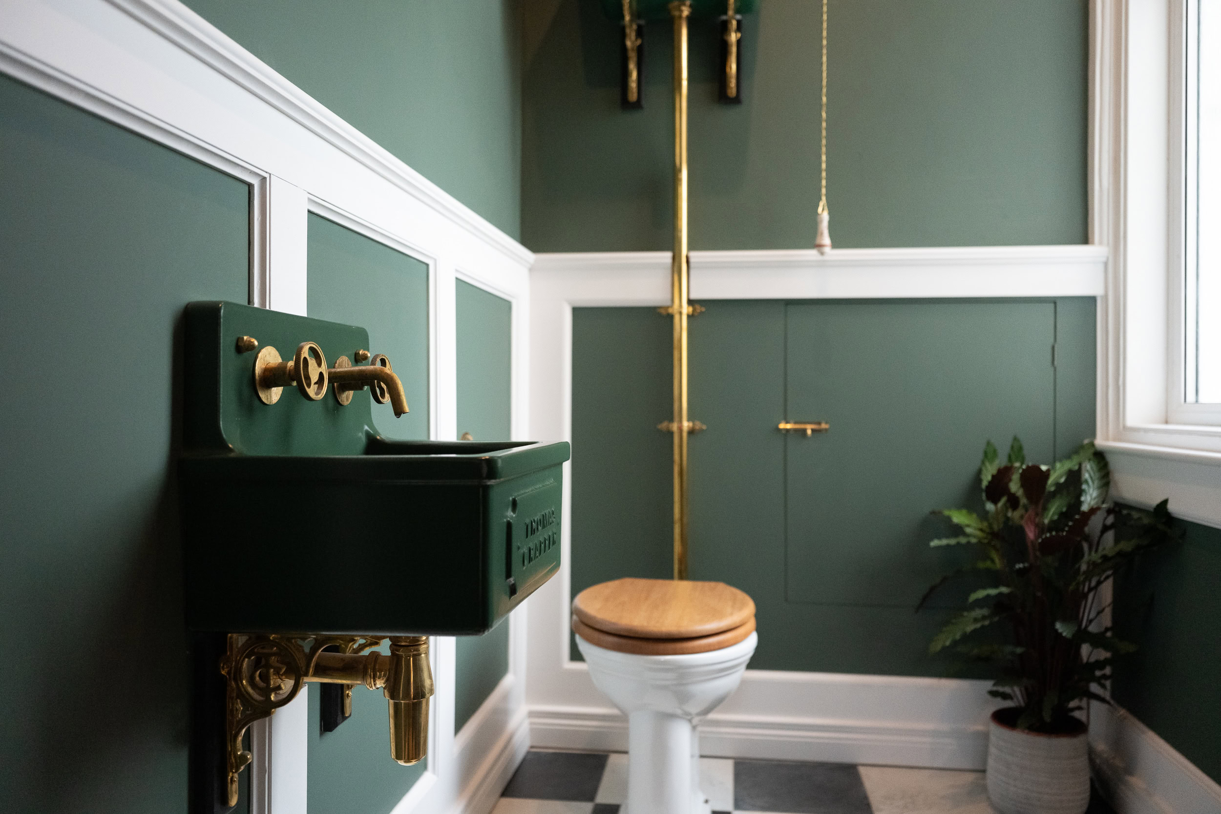 Dark green bathroom with industrial-style fittings