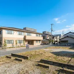 大阪の住宅地にある更地または建て替え候補地を前景に、背景に高齢者施設や街並みを置いた写真