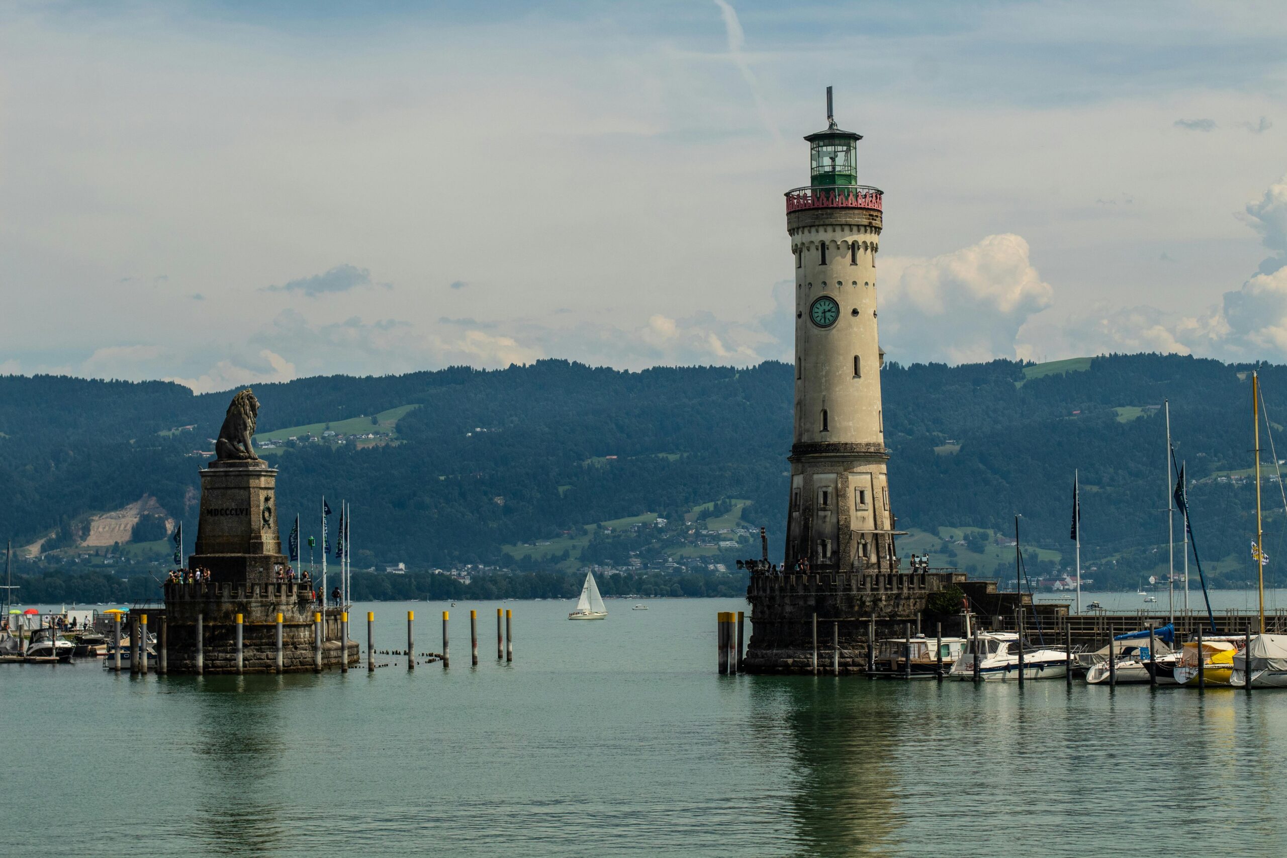 The iconic Lindau Lighthouse and Bavarian Lion statue at Lake Constance in a serene setting.