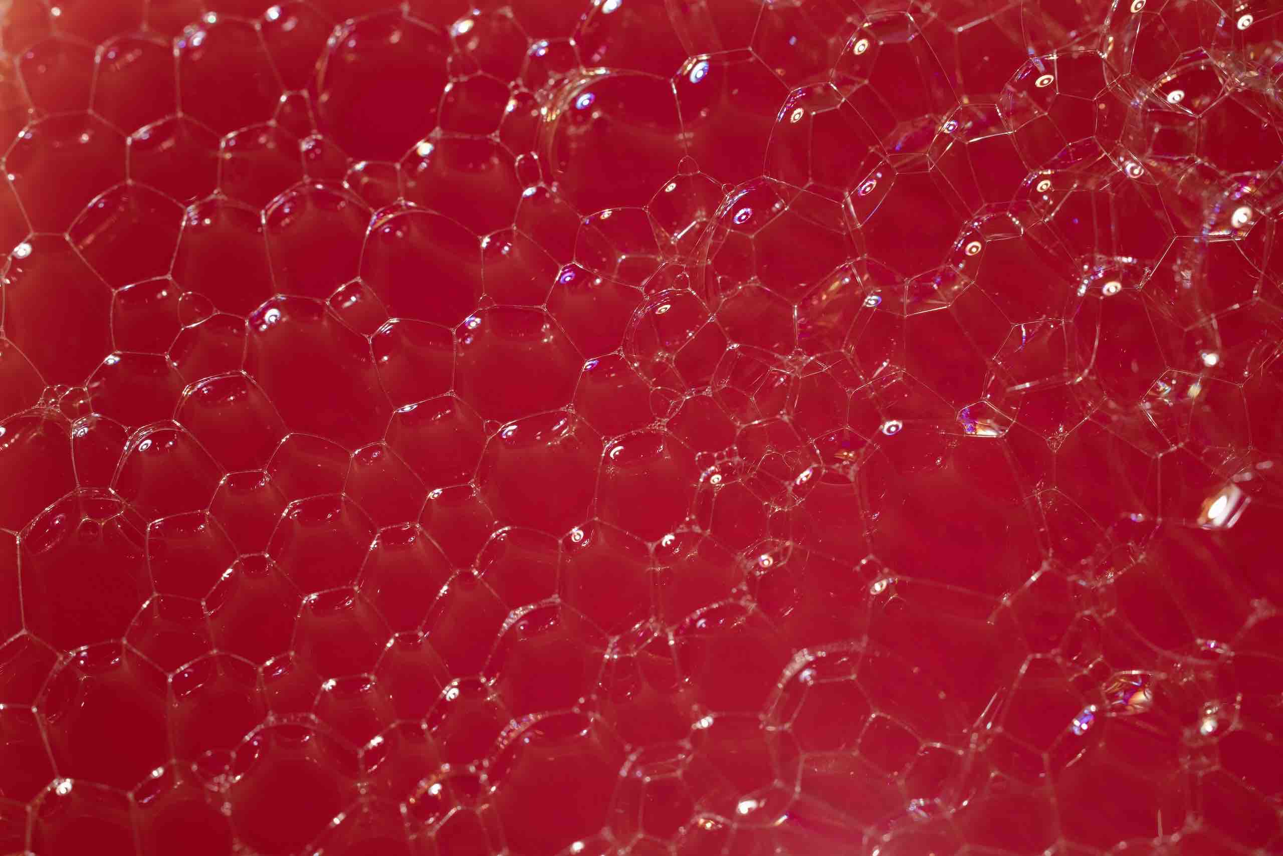 Red soap foam and bubbles close up