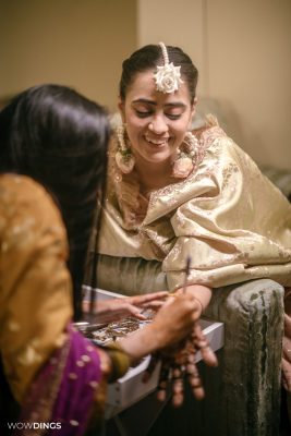 Muslim bride's hands with intricate mehndi designs during a vibrant ceremony
