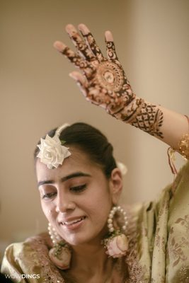 Muslim bride's hands with intricate mehndi designs during a vibrant ceremony