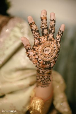 Muslim bride's hands with intricate mehndi designs during a vibrant ceremony