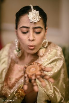 Muslim bride's hands with intricate mehndi designs during a vibrant ceremony