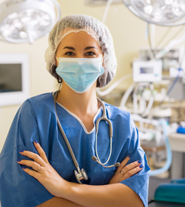 Smiling healthcare worker in scrubs with face mask. Medical professional in scrubs wearing a mask and smiling at the camera.