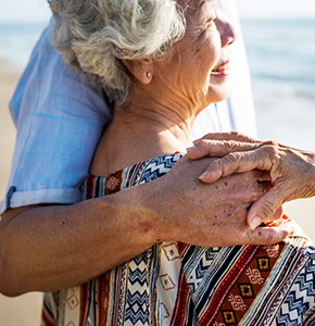 Husband giving his wife a hug on the beach