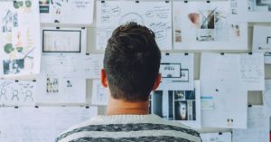 A man looking at a bulletin board - Top 5 Tips for Buying a Business - March 2022 blog image