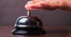 A hand ringing a bell - Time to Sound the Sell Bell? - March 2022 blog image