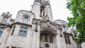 Image of the High Court in London, UK from the perspective of looking up at the tower with part of a tree showing to the right hand side. This follows the announcement that The Judicial Review claim relating to the Department for Education’s proposed operating model for its new arm’s length body, Oak National Academy, has been granted permission to proceed by the High Court.