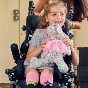 Child using winged contour headrest on lilac specialist seating showing lateral head support and positioning in daily use
