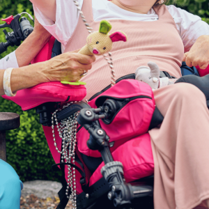 Close-up lifestyle image of elbow blockers supporting a wheelchair user’s arms