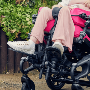 Lifestyle image of Sophie using wheelchair footplates for secure foot positioning